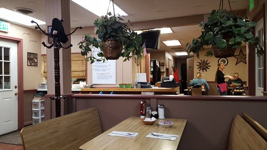 Dining room at Main Street Grille with hanging plants and red curtains